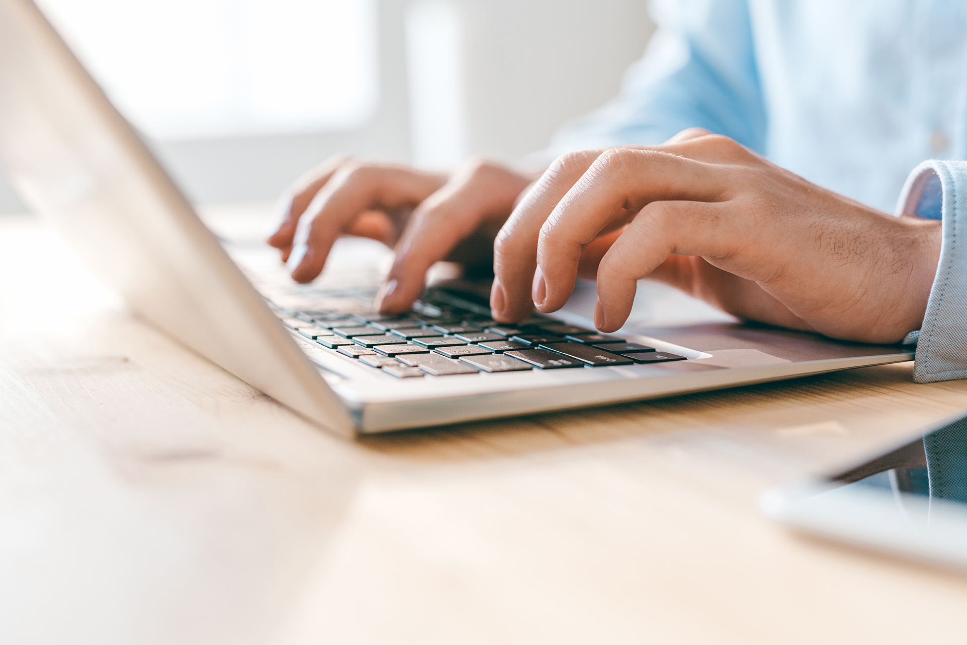 Hands of young businessman or analyst pressing keys of laptop keypad