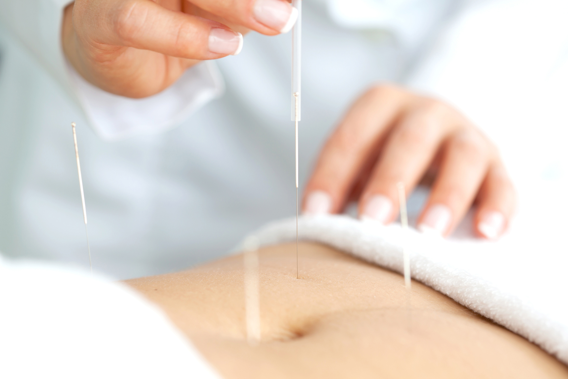 Acercamiento de las manos de una doctora aplicando un tratamient